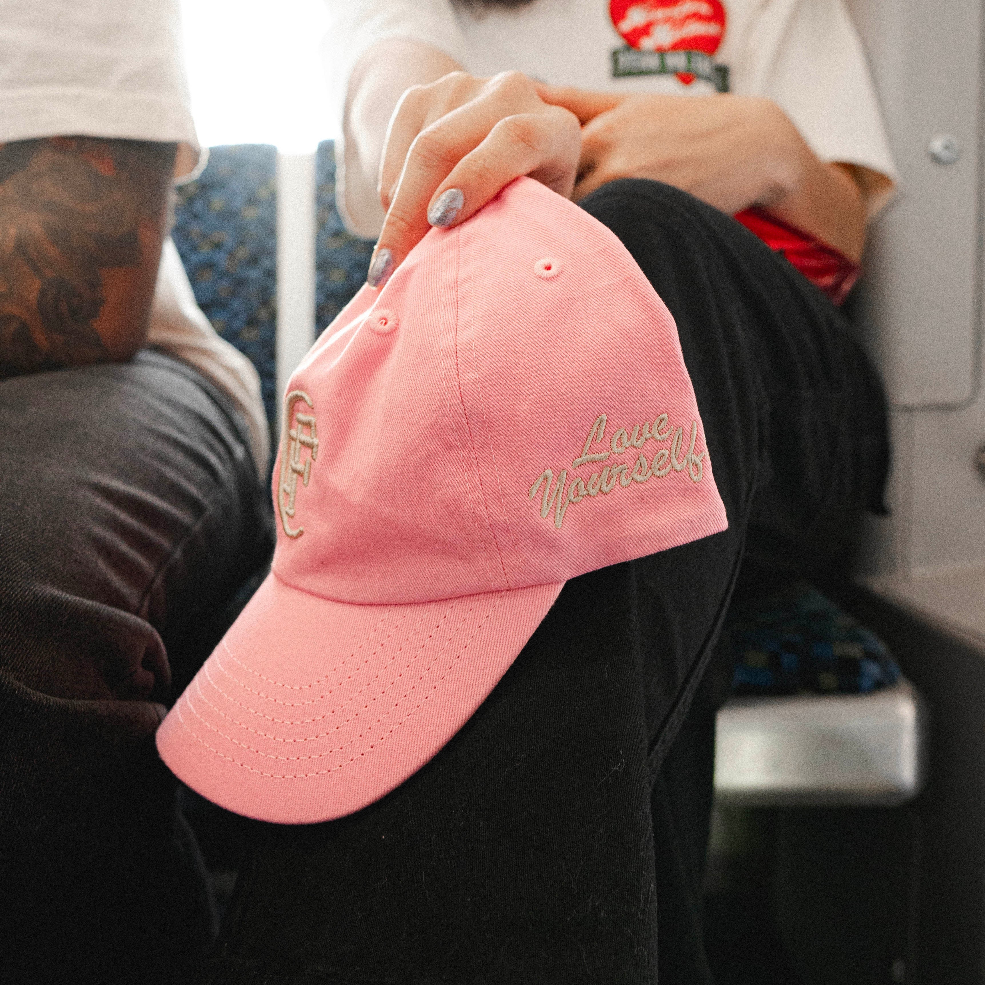 A pink baseball cap is being shown from the side.